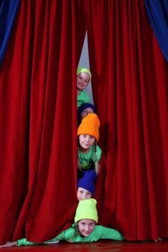 Kinder schauen durch Zirkusvorhang im Spielecircus