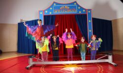 kostümierte Kindergarten verbeugen sich in der Manege vor dem Drahtseil