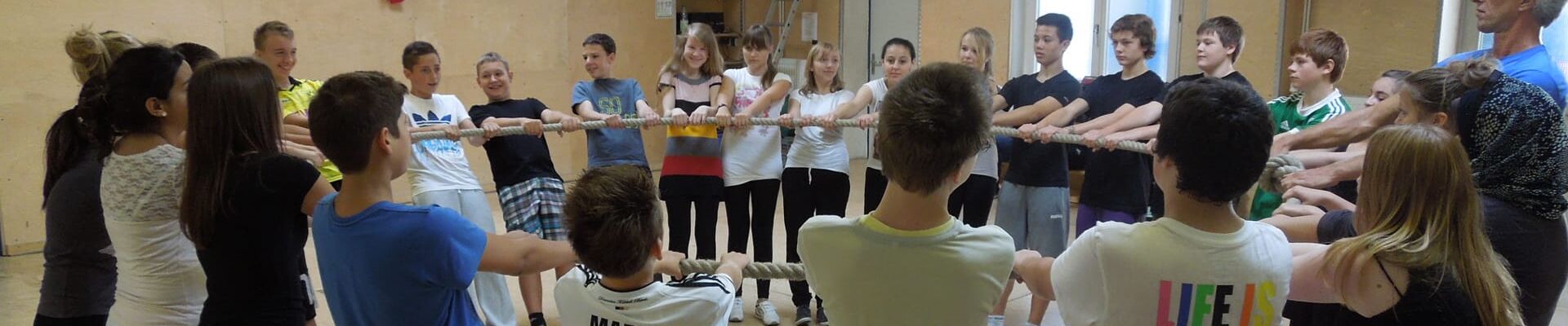 Jugendliche beim Teamspiel Balance mit dem Tau